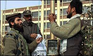 Afghan policemen lower the Taleban flag in Kabul